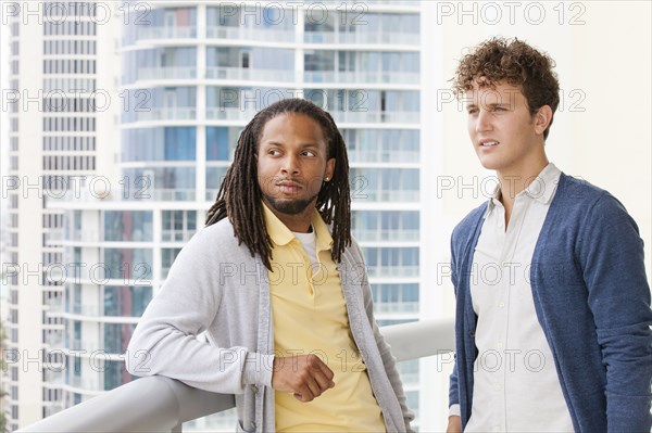 Businessmen standing on urban balcony