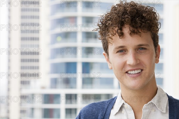 Caucasian man smiling on urban balcony