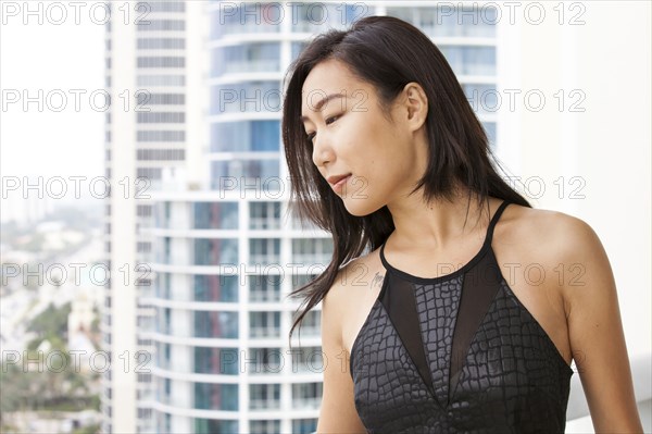 Asian woman on urban balcony