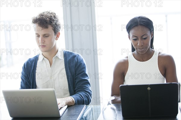 Business people working on laptops in office