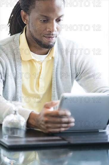 African American businessman using digital tablet in restaurant