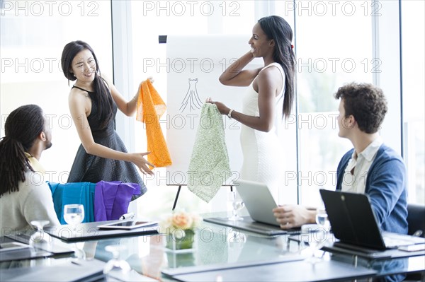 Business people examining fabric samples in office meeting