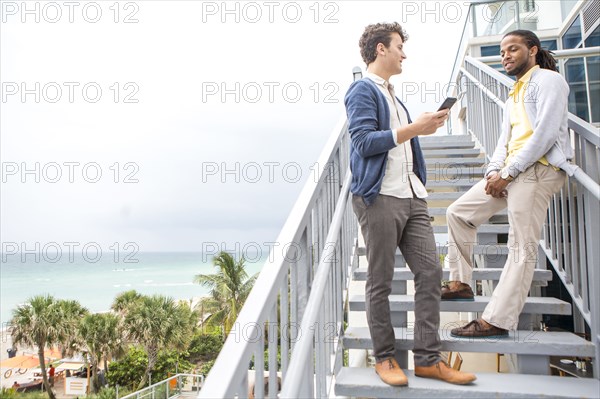 Businessmen talking on steps over urban beach