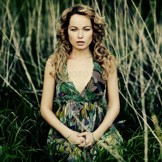 Caucasian woman sitting in tall grass