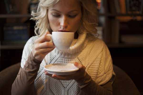 Caucasian woman drinking cup of coffee