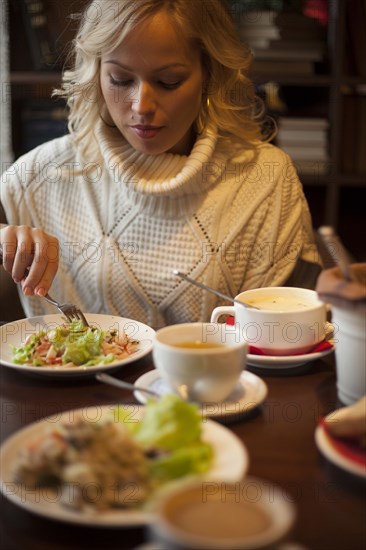 Caucasian woman eating at table