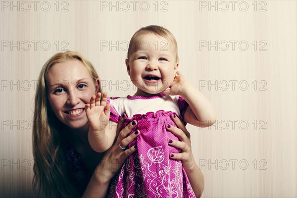 Caucasian mother holding baby daughter