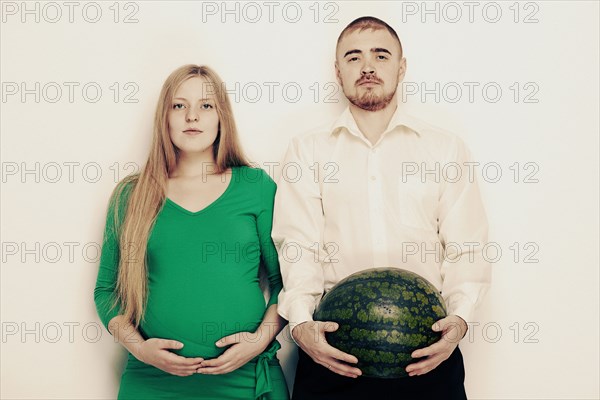 Man holding watermelon with pregnant girlfriend