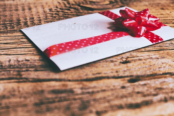 Ribbon on valentine card on wooden table