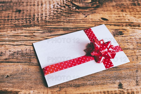 Ribbon on valentine card on wooden table