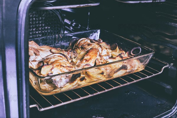 Potato and chicken casserole baking in oven