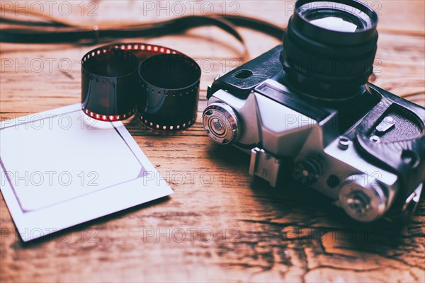 Cameras on wooden table with film and photograph