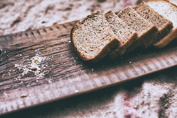 Close up of slices of bread and crumbs on wooden tray