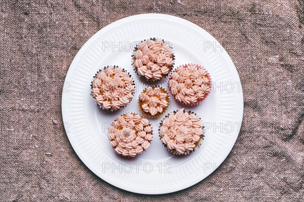 Close up of cupcakes with pink frosting on plate