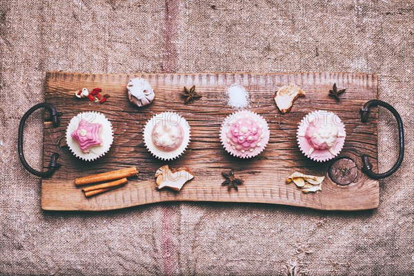 Cupcakes on ingredients on wooden tray