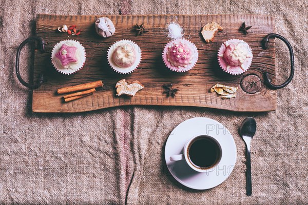 Cupcakes on ingredients on wooden tray with coffee