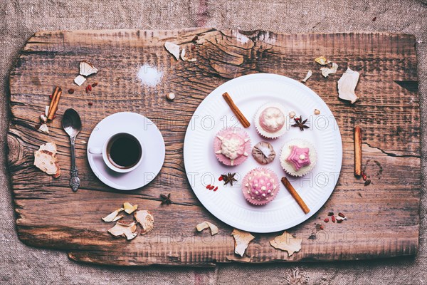 Cupcakes on ingredients on wooden tray with coffee