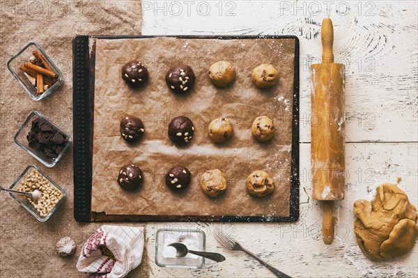 Cookie dough on baking sheet near rolling pin and ingredients