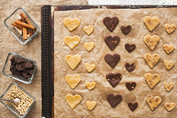 Heart-shape cookies on baking sheet near ingredients