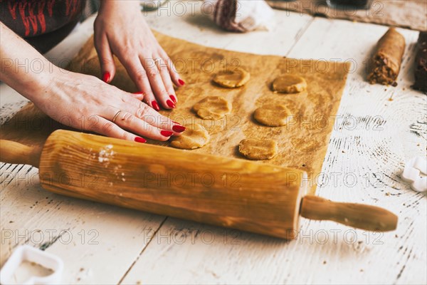 Hands of woman pressing cookie dough on baking sheet