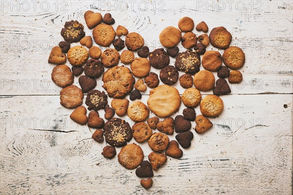 Variety of cookies on wooden table in heart-shape