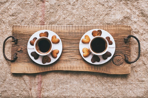 Coffee and heart-shape cookies on wooden tray