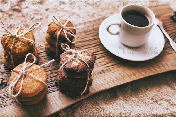 Coffee and bundles of cookies on wooden tray