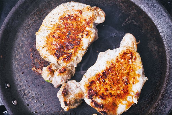 Pork chops searing in pan