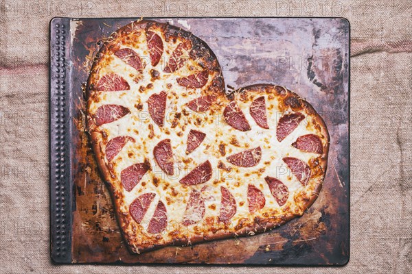 Heart-shaped pizza on pan