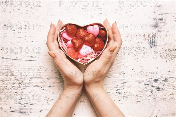 Hands of woman cupping valentine gift box