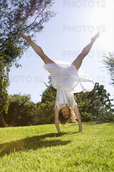 Woman doing cartwheel in park