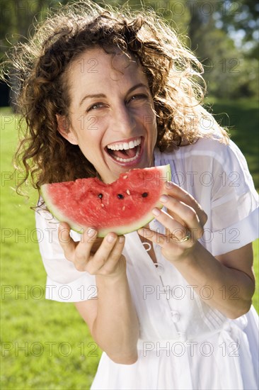 Smiling woman eating watermelon