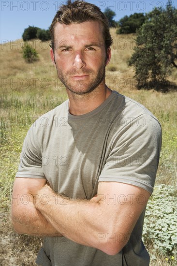 Serious man standing in remote field