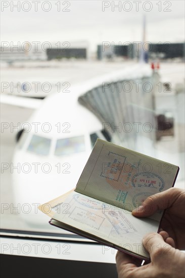 Caucasian man looking at passport in airport