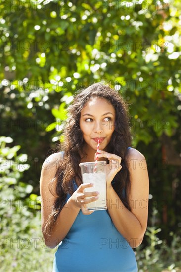 Mixed race woman drinking lemonade outdoors