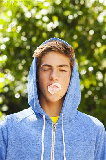 Caucasian teenager blowing bubble with gum