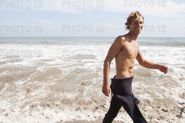 Caucasian surfer walking on beach