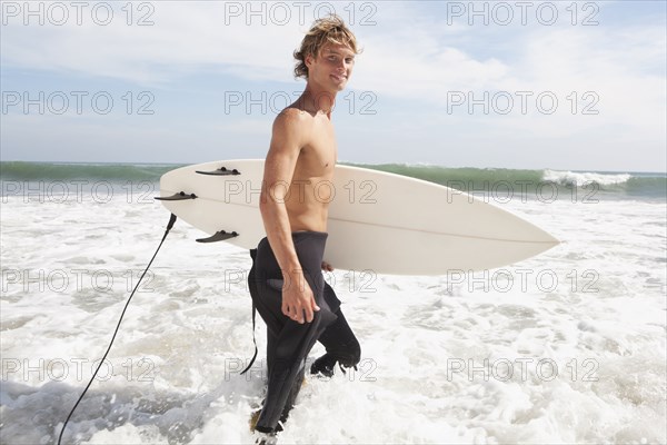 Caucasian surfer carrying surfboard