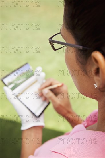 Woman keeping score during golf game