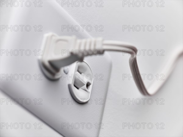 Close up of white plug in outlet