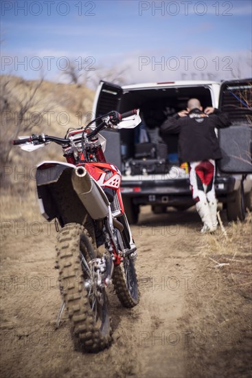 Close up of motorcycle behind dirt bike rider and van