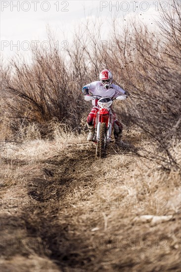 Motorcyclist riding dirt bike on rural path