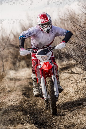 Motorcyclist riding dirt bike on rural path