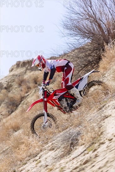 Motorcyclist riding dirt bike in remote field