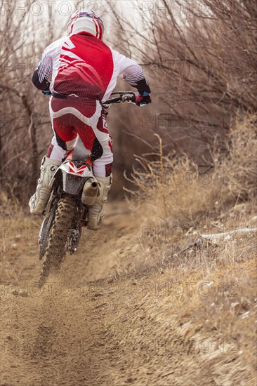 Motorcyclist riding dirt bike on rural path