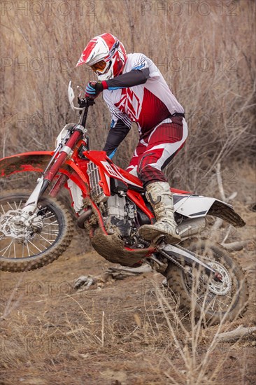 Motorcyclist riding dirt bike on rural path