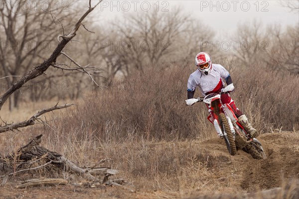 Motorcyclist riding dirt bike on rural path