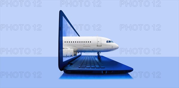 Airplane emerging from laptop screen