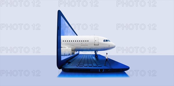 Airplane emerging from laptop screen with pilot walking on keyboard
