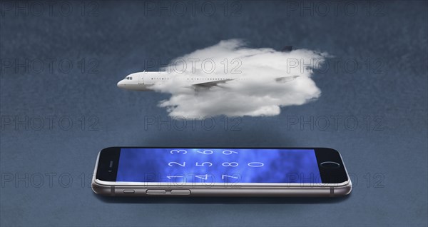 Airplane in cloud floating over cell phone